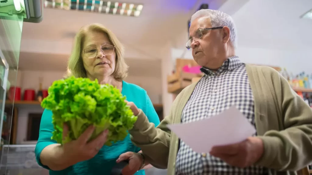 Casal escolhendo vegetais: motivos de brigas de casal no supermercado