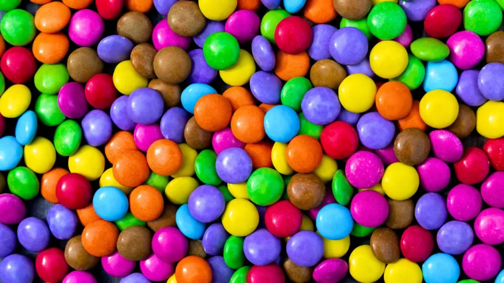 Variados e coloridos chocolates em formato de confetes, um, chamariz para crianças.